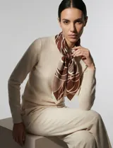 Pañuelo cuadrado de seda con estampado floral en tonos verdes, marrones y blancos.