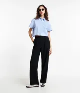 Pantalón de vestir negro, de corte recto, con cintura asimétrica y cierre por botón y cremallera.