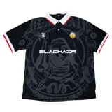 Camisa tipo polo roja de manga corta con cuello blanco y ribetes blancos en las mangas. Presenta un estampado grande en negro con una figura femenina en el centro, la palabra "BLACHAIR" y otros gráficos de estilo gótico/urbano.