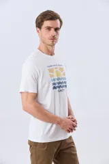 Remera blanca de manga corta y cuello redondo, con estampa frontal inspirada en el mar y atardeceres de verano con la inscripción 'Travel. Beach. Repeat.' y 'Legacy'.