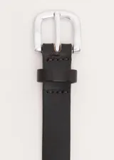Cinturón fino de cuero de piel bovino color negro, con diseño decorado con tachas metálicas plateadas y cierre de hebilla metálica.