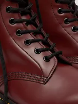 Bota Dr. Martens modelo 1460 de cuero color cereza, con 8 ojales, costuras amarillas y suela con cámara de aire.