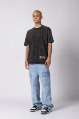 Remera de algodón con efecto desgastado acid wash, corte semi-oversize, cuello redondo y estampa gráfica pequeña en la parte inferior frontal.