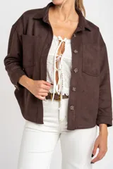 Sobrecamisa de gamuza sintética en color marrón chocolate, con corte oversize, cuello camisero, cierre frontal con botones y bolsillos frontales tipo parche.