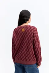 Buzo de punto con diseño geométrico en zigzag, de cuello redondo y manga larga. Presenta un calce holgado y cómodo con puños y ruedo acanalados.