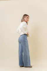 Jean wide leg de tiro alto con calce relajado y pierna amplia. Confeccionado en denim con leve desgaste, cuenta con cintura definida con presillas, bolsillos clásicos y cierre frontal con botón metálico.