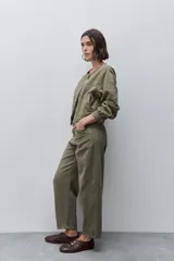Jean straight de tiro alto y pierna recta, color verde militar, de aspecto limpio con cinco bolsillos, cierre frontal con botón y presillas para cinturón.