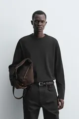 Camiseta de manga larga con corte relajado, confeccionada en tejido compacto de algodón. Presenta cuello redondo acabado en rib y detalle de costura central en la espalda.