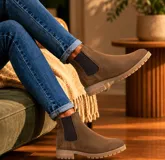 Bota tipo Chelsea de cuero negro con paneles laterales elásticos y suela de goma dentada.