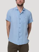 Camisa de manga corta RKF modelo Linenpro, color celeste, confeccionada en lino 100% orgánico, con cuello abierto, cierre frontal de botones y un bolsillo aplicado en el pecho.