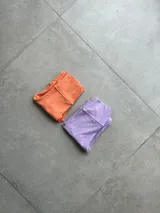 Calza deportiva larga color durazno, tiro alto y textura acanalada.