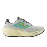 Championes de running New Balance modelo More V5, con tecnología Fresh Foam X en la entresuela para máxima amortiguación. Presentan un diseño de malla transpirable en color gris con detalles en turquesa y amarillo, y una suela voluminosa en tono crema.