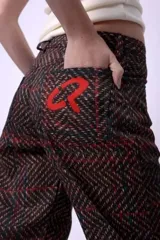 Pantalón de corte recto y largo al tobillo, con estampado geométrico en tonos oscuros y líneas rojizas. Posee tiro medio y cierre frontal.