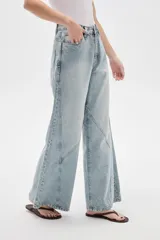 Pantalón de jean de corte ancho y tiro alto, con diseño de costuras decorativas en las piernas.