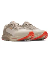Championes de trail running Under Armour Charged Bandit TR 3, color beige con detalles en naranja. Presentan una parte superior de malla transpirable con refuerzos estratégicos, entresuela Charged Cushioning para mayor amortiguación y suela exterior con tacos técnicos para tracción en senderos.