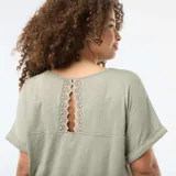 Camiseta de tejido crepé en color verde, con escote en V y mangas cortas con dobladillo fijo.