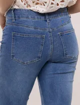 Jean de denim azul con elasticidad confortable, tiro medio, cierre frontal con cremallera y doble botón metálico. Cuenta con diseño de cinco bolsillos y corte bootcut, ajustado en muslos con un sutil ensanchamiento hacia el ruedo.