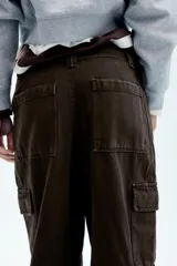 Pantalón cargo de tiro medio confeccionado en denim negro con efecto lavado. Presenta bolsillos laterales con solapa, bolsillos delanteros y traseros, corte recto y cinturón del mismo tejido incluido con hebilla metálica.