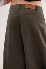 Pantalón de tiro medio con diseño de pierna ancha y cortes curvos que aportan movimiento. Presenta cintura ajustada, bolsillos delanteros y bolsillos plaque en la parte trasera.