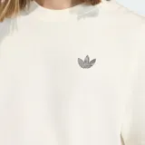 Remera de algodón de corte holgado, color blanco, con cuello redondo y mangas cortas. Presenta un pequeño logo de Adidas Originals bordado en el pecho y una etiqueta decorativa en el ruedo lateral.