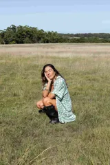 Camisa maternal de corte holgado y largo midi, confeccionada en viscosa suave con estampado geométrico de cuadros en color verde agua y blanco. Presenta cuello camisero, mangas cortas y bolsillos laterales.