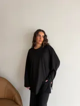 Conjunto oversize de dos piezas en tejido acanalado color beige, compuesto por una remera de manga larga con aberturas laterales y un pantalón largo de corte recto y holgado.