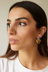 Aros con diseño colgante de dos corazones metálicos abombados, uno superior plateado y uno inferior dorado.