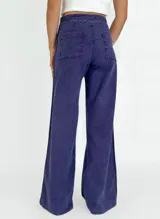 Pantalón de jean de tiro alto, corte palazzo, color ladrillo con costuras laterales a contratono.