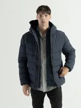Campera acolchada con capucha integrada y cuello alto. Presenta cierre frontal completo, bolsillos laterales con cierre y puños con terminaciones elásticas para mayor protección contra el frío.