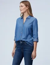 Camisa de tencel color azul medio, con cuello con solapa, escote en V y abertura central con botones. Las mangas largas se pueden enrollar y sujetar con presilla. El largo de espalda es mayor al delantero, con tajo central.