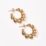 Aros tipo argolla dorados con diseño retorcido.