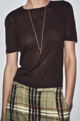 Top de manga corta color beige claro, con cuello redondo y textura de tejido de punto fino.