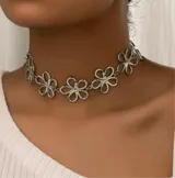 Gargantilla plateada con eslabones y dijes en forma de flores caladas.