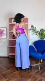 Pantalón sastrero de corte amplio y tiro alto, color rojo vibrante. Presenta pinzas en la cintura, cierre frontal con botón a la vista y diseño de pierna ancha.