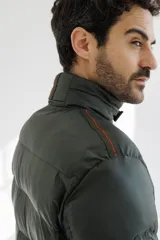 Campera puffer color verde militar, con cuello alto y cierre frontal.