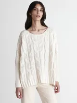 Sweater color crema con cuello redondo y diseño de trenzas grandes.