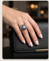 Anillo de plata 925 con diseño calado y piedra facetada azul en forma ovalada.