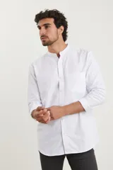 Camisa blanca de manga larga con cuello mao y bolsillo en el pecho.