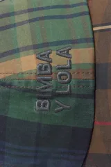 Gorra de béisbol con diseño patchwork de cuadros en tonos marrones, verdes y azules. Presenta el logo de la marca bordado en el frente y visera curva.