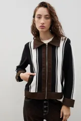 Campera de estilo casual confeccionada en una combinación de tejido de punto a rayas verticales en blanco y negro, con detalles en denim marrón en cuello, puños, ruedo y cierre frontal.