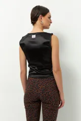 Top sin mangas de satén color gris topo, con cuello redondo y cordones laterales para fruncir.