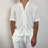 Camisa de manga corta confeccionada en tejido de punto con textura calada, corte boxy y cuello solapa.