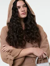 Vestido tipo túnica con capucha y bolsillo canguro frontal, de corte holgado y largo midi.