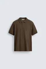 Remera polo de hombre en color marrón, de corte regular fit y diseño de estructura vertical en el tejido. Cuenta con cuello solapa, cierre frontal con botones y mangas cortas con terminación en rib.