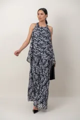 Vestido largo de gasa con estampa en blanco y negro, de líneas simples y escote halter. Cuenta con una sobrecapa cruzada en el frente.