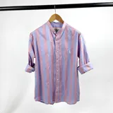 Camisa de hombre a rayas verticales anchas en celeste y rosa pálido, con cuello mao y mangas largas con puños abotonados.