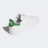 Championes Adidas Stan Smith, modelo clásico de corte bajo, color blanco con detalles en verde. Presentan una parte superior de cuero sintético, perforaciones laterales en lugar de las tres franjas y talón en color verde con logo.