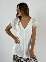 Blusa blanca de viscosa con escote en V y mangas cortas de encaje floral.