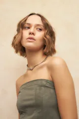 Top strapless negro con diseño tipo corset, de textil engomado y texturizado.