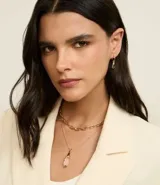 Conjunto de accesorios compuesto por un collar de cadena de eslabones, un collar con dije de cristal y un par de aros tipo argolla con dije de cristal. Piezas con acabado en tono dorado.